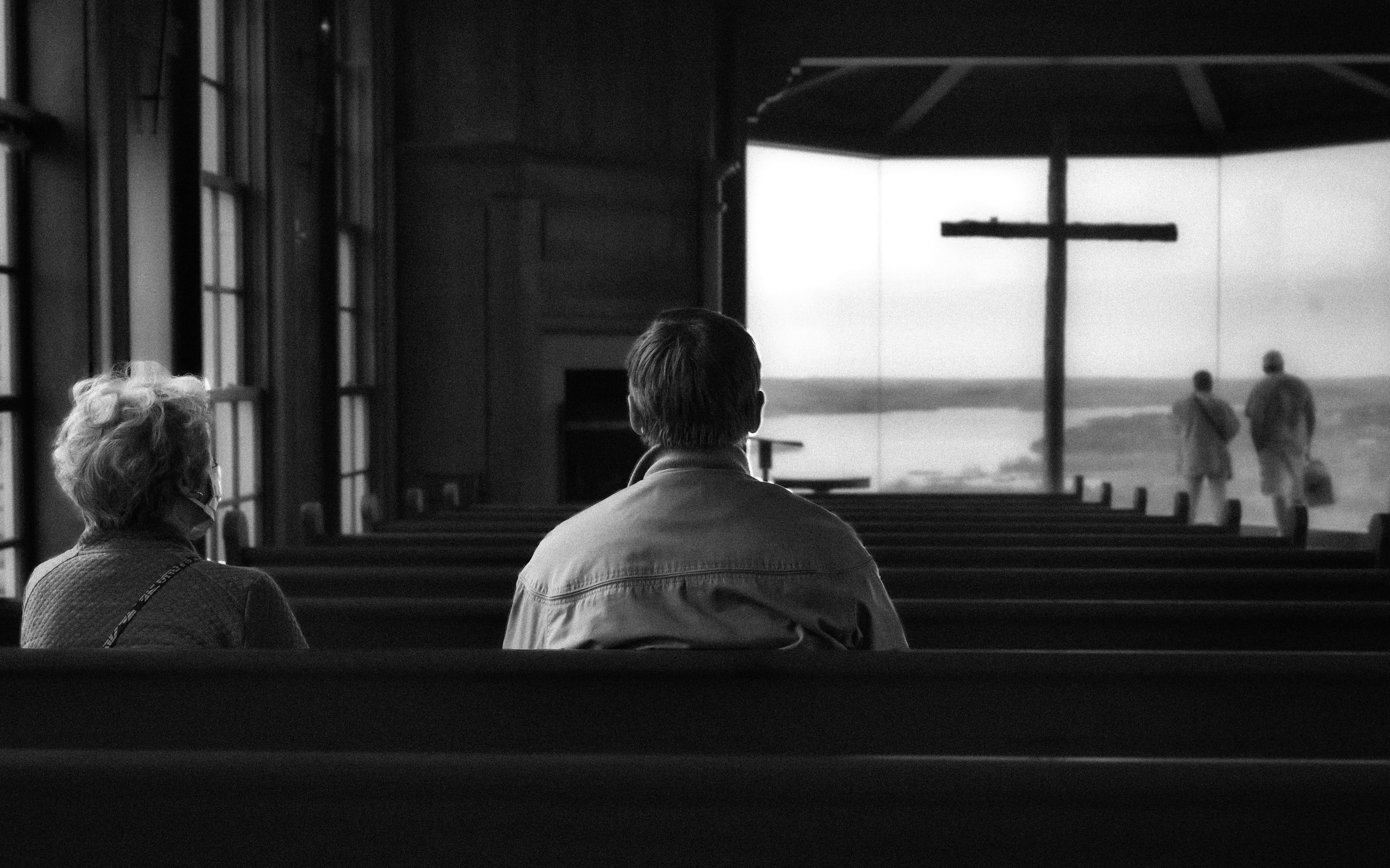 grayscale photo of man in dress shirt sitting on bench